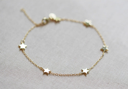 Six tiny little stars hang alongdelicate chain. Works great layered with other bracelets or all alone.
Details:

6 inches long with 2 inch extender
14kt gold